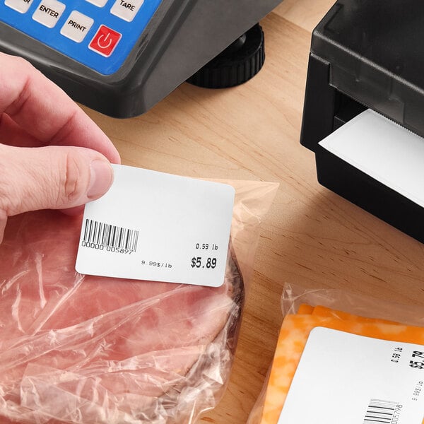 A roll of white blank permanent direct thermal labels used for pricing and barcoding packaged food items.