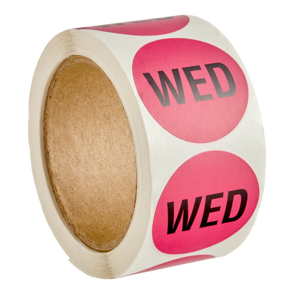 A roll of round pink labels with the word 'WED' printed in bold black letters.