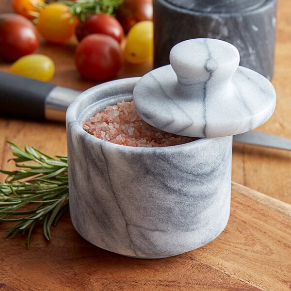 A white marble Fox Run salt cellar with a lid containing salt.