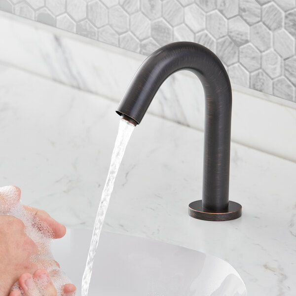 A person washing their hands under a Waterloo hands-free sensor faucet.