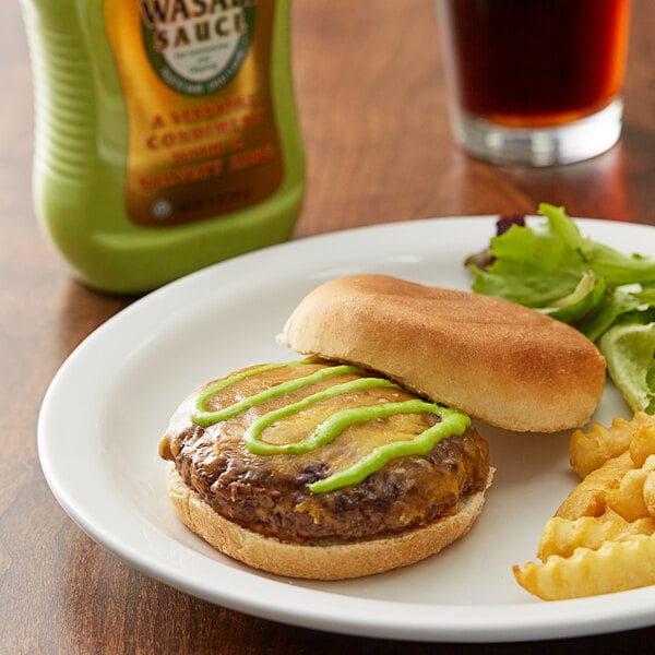 A plate of food with a burger and fries and a Kikkoman Wasabi Sauce bottle.