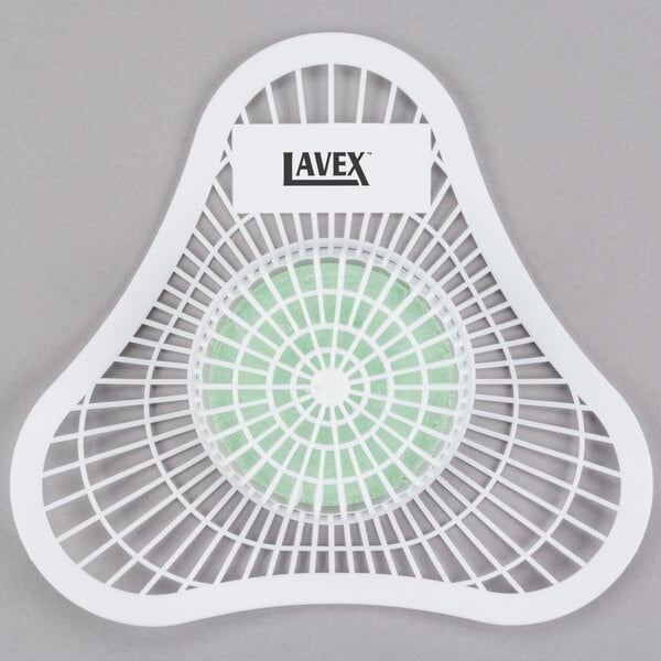 A white plastic Lavex urinal screen with a green circle.