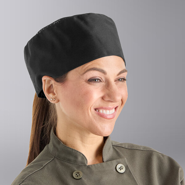 A woman wearing a black Uncommon Chef mesh top chef hat with hook and loop closure.