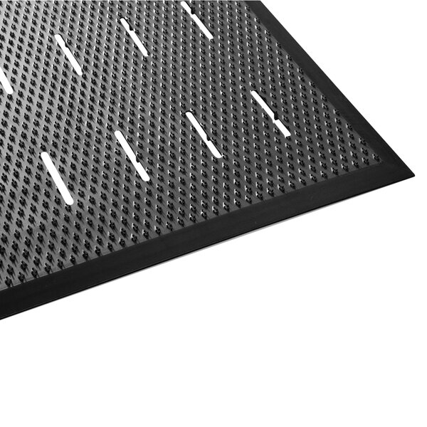 A close-up of a black Guardian Free Flow Comfort utility floor mat with holes in it.