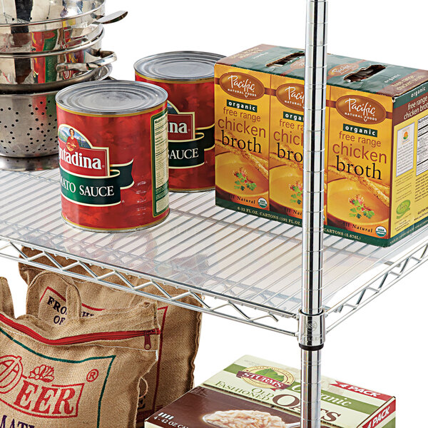 A metal wire shelf with Alera clear plastic liners holding canned and boxed food.