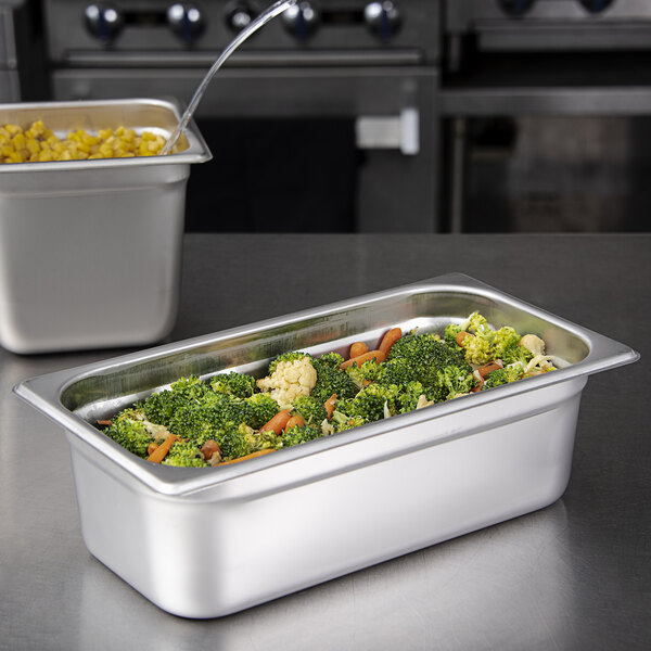 A Carlisle stainless steel steam table pan filled with broccoli and carrots.