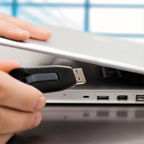 A hand holding a Verbatim Store 'n' Go V3 USB flash drive.