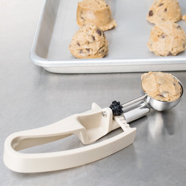 A Vollrath beige Jacob's Pride cookie dough scooper on a tray.