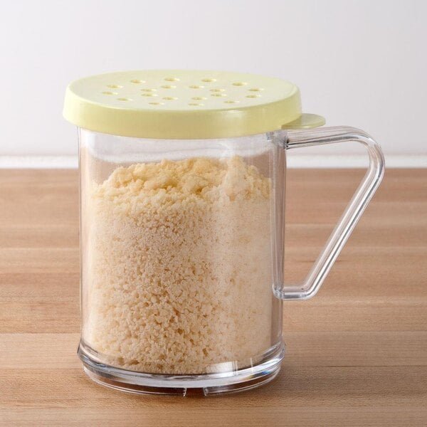 A Tablecraft polycarbonate shaker with a yellow lid filled with white powder.