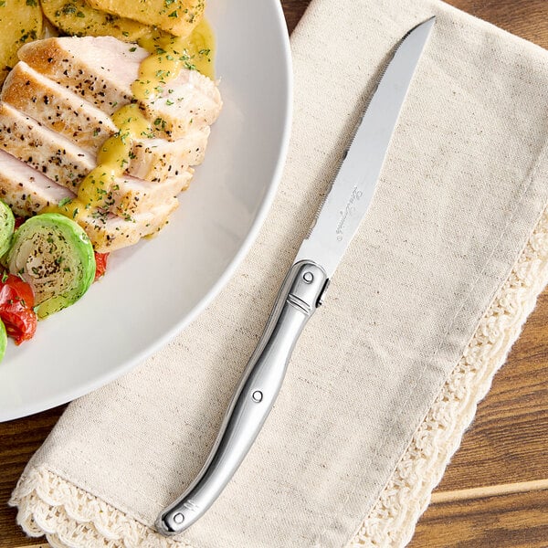 A plate of food with a Lou Laguiole steak knife on it.