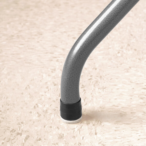 A metal leg with a black rubber Master Caster Quiet Feet on it.