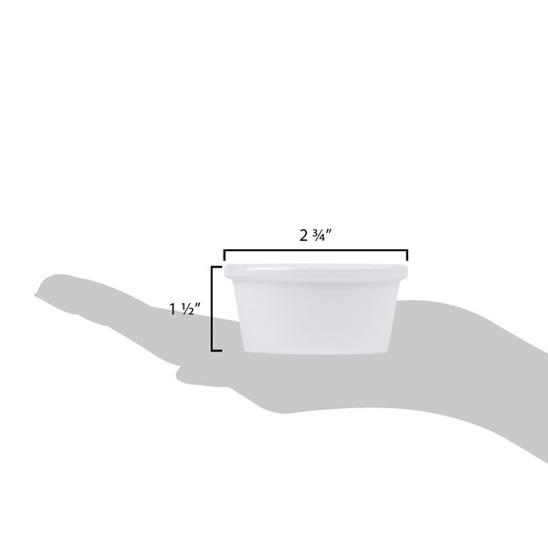 A hand holding a white Carlisle oval ramekin with a handle.