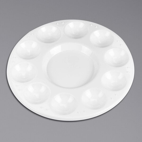 A white round plastic paint tray with 10 small wells.