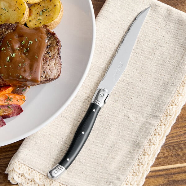 A plate of food with a Lou Laguiole steak knife on it.