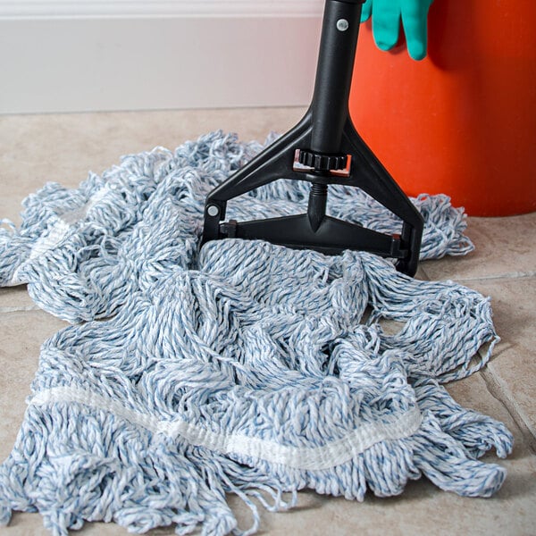 A Carlisle mop handle with a plastic head on the floor with a mop.