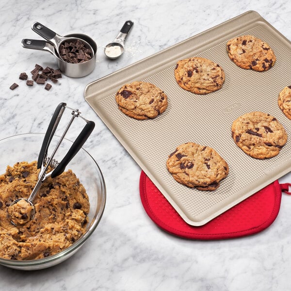 An OXO stainless steel measuring cup with chocolate chunks in it.