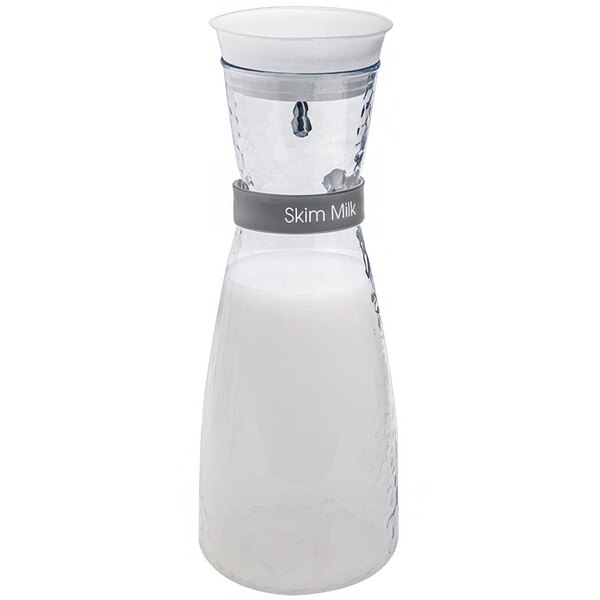 A Front of the House glass carafe with Drinkwise reusable labels filled with white liquid.