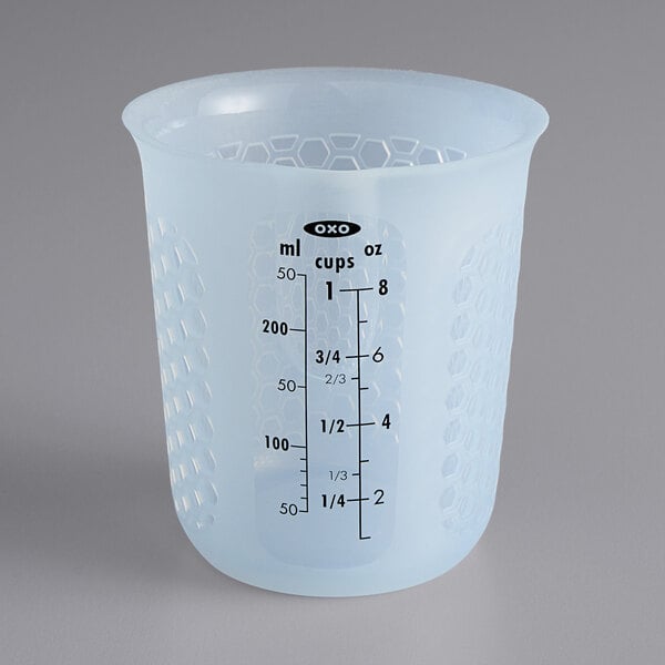 A translucent plastic OXO measuring cup with black text on a white background.
