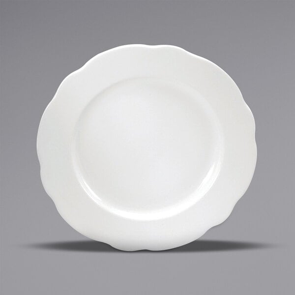 A close-up of a Oneida Buffalo Caprice cream white china plate with a scalloped edge.
