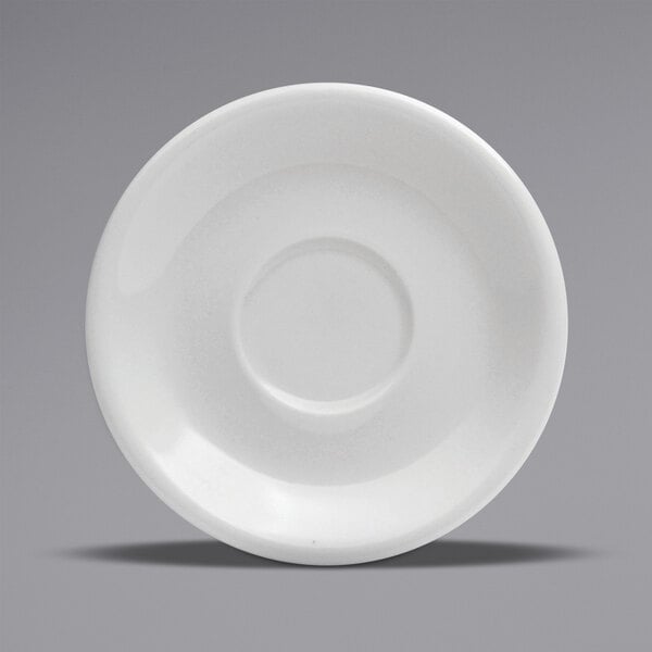 A white porcelain saucer with a circle in the middle and a rim.