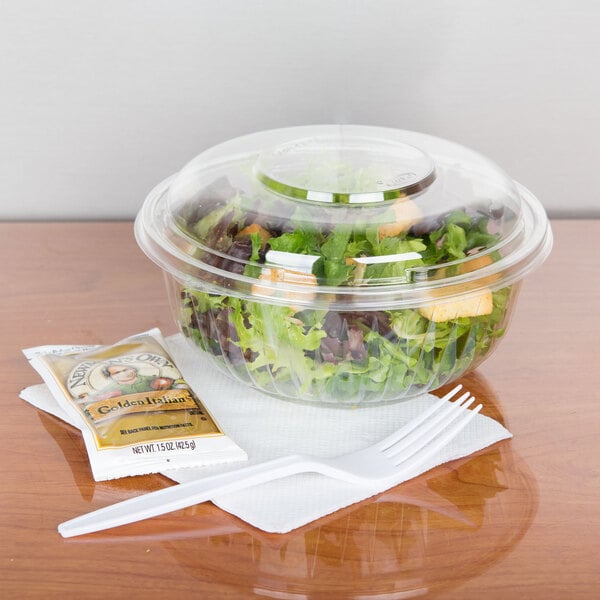 A salad in a Dart clear plastic bowl with a fork.