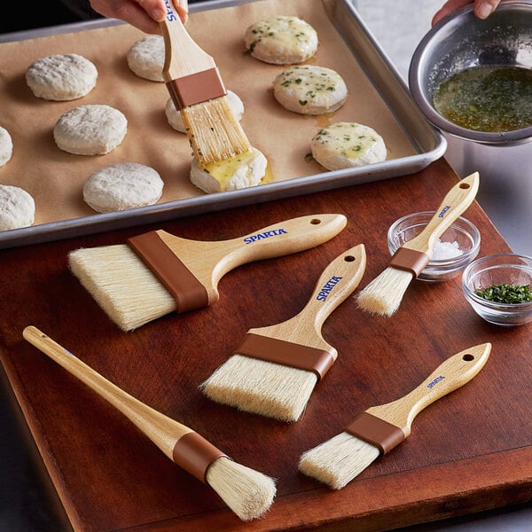 A person using a Carlisle Sparta Chef Series boar bristle brush to make bread.