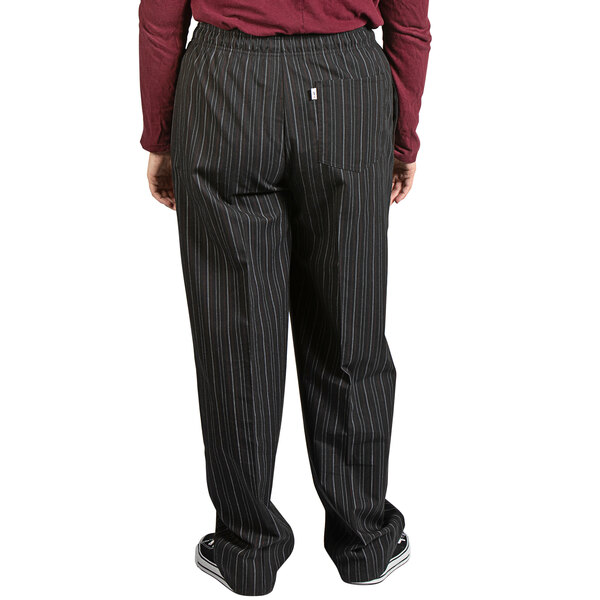 A person wearing red and white pinstripe chef pants.