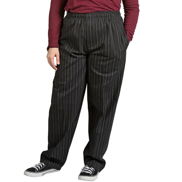 A person wearing Uncommon Chef red and white pinstripe pants with black pants and a maroon shirt.