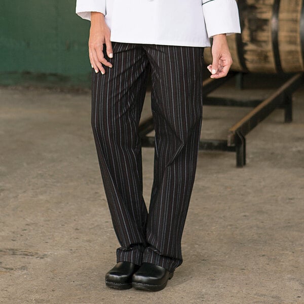 A person wearing Uncommon Chef red and white pinstripe pants and a white shirt.