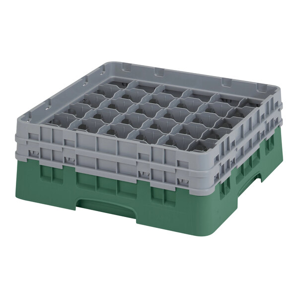 A green and gray plastic Cambro glass rack with many compartments and holes.