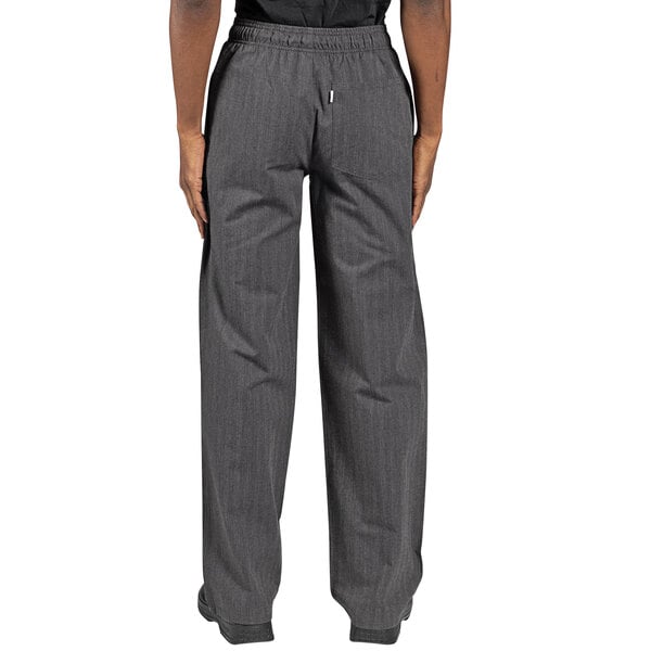 The legs of a person wearing Uncommon Chef broken twill grey chef pants.