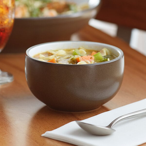 An Acopa Embers hickory brown stoneware bowl filled with soup on a table.