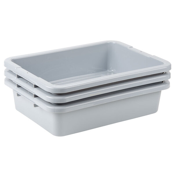 A stack of three Rubbermaid gray plastic bus tubs.