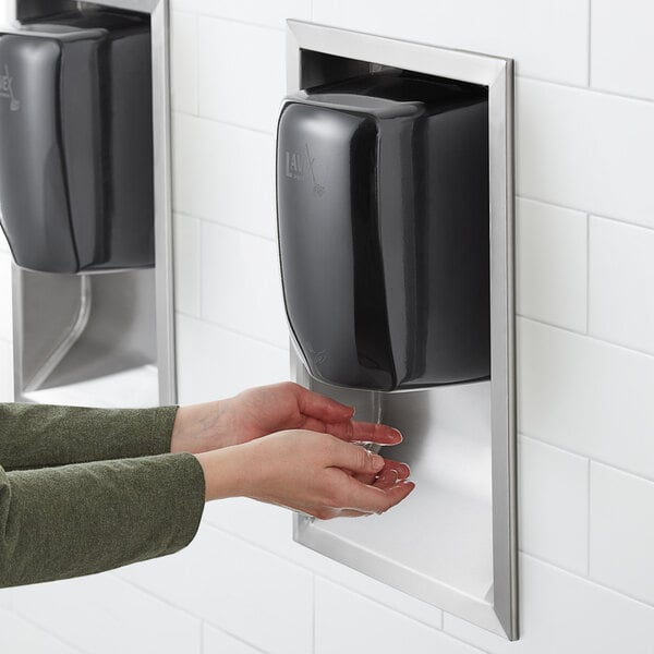 person drying hands under electric hand dryer