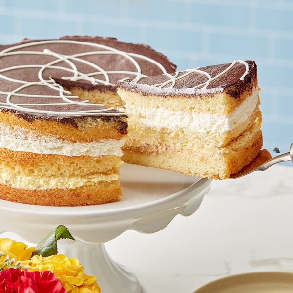 A slice of yellow cake with white frosting on a white plate.