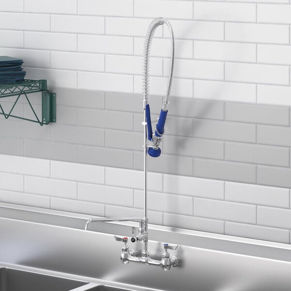 A Waterloo wall-mounted pre-rinse faucet with an add-on faucet above a sink in a school kitchen.