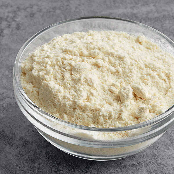 A bowl of Krusteaz Professional All-Purpose Creme Cake mix powder on a table.
