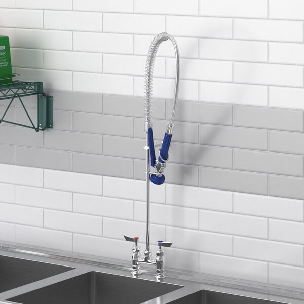 A Waterloo pre-rinse faucet assembly with a riser, hose, and spray valve installed on a kitchen sink.