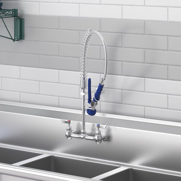 A white wall-mounted pre-rinse faucet with an 8" center and hose.