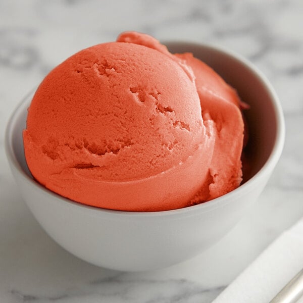 A bowl of I. Rice watermelon ice with a scoop of ice cream on top.