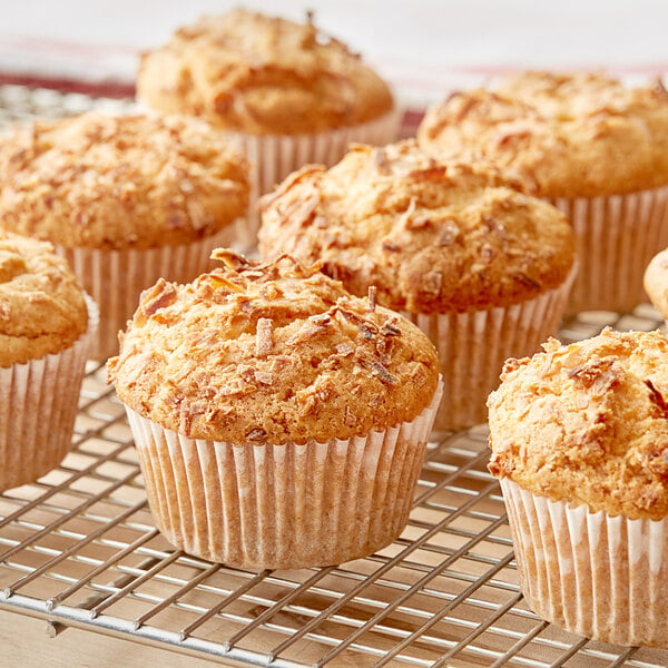 Krusteaz Professional all-purpose muffins in wrappers on a cooling rack.