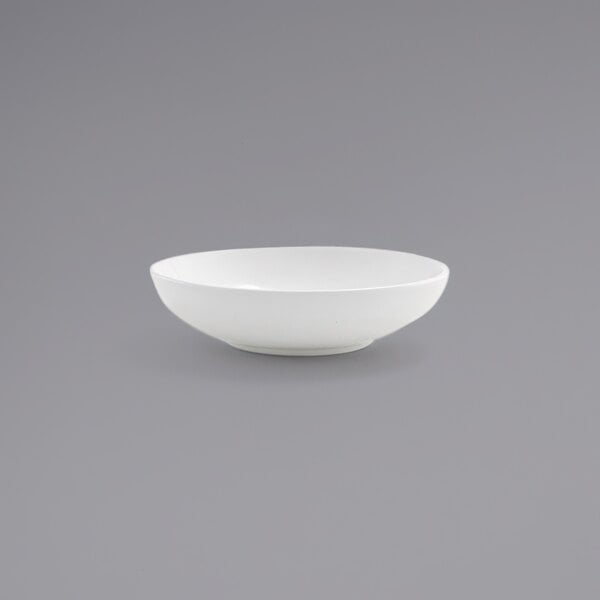 A Front of the House Harmony bright white low round porcelain bowl on a gray background.