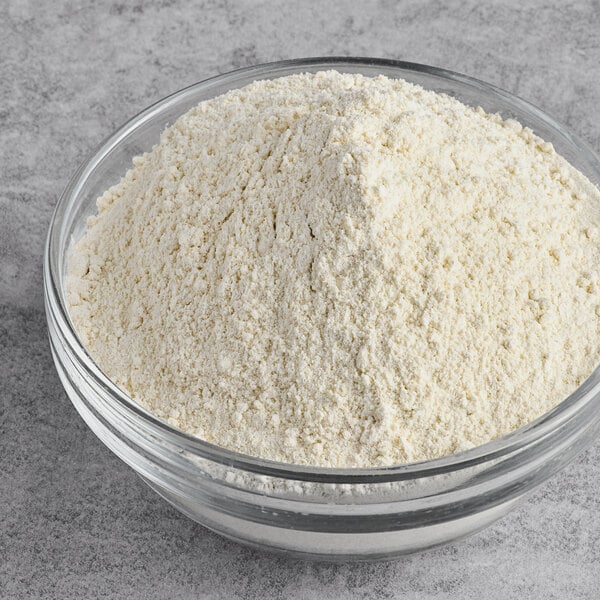 A clear glass bowl filled with finely ground white cassava flour.