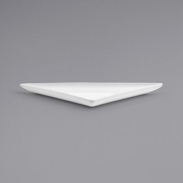 A Front of the House bright white triangle porcelain plate on a gray surface.
