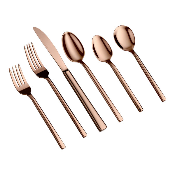 Six pieces of rose gold-colored flatware, including two forks, one knife, and three spoons, are arranged side by side on a white background.