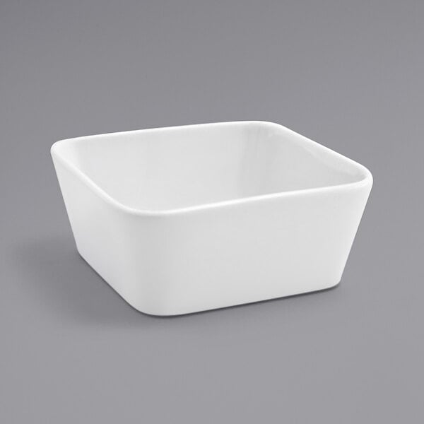 A Front of the House Mod bright white square porcelain bowl on a gray surface.