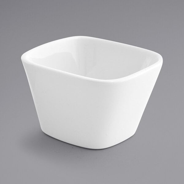 A Front of the House bright white square porcelain bowl on a gray background.