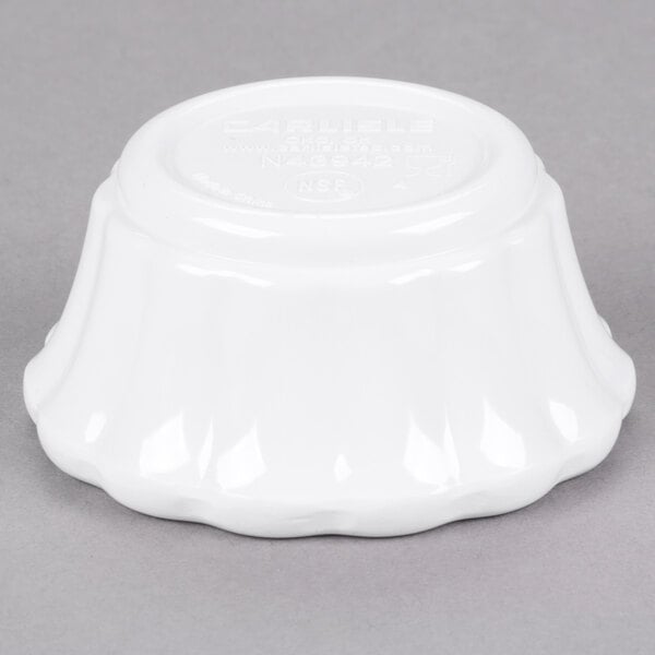 A white Carlisle scalloped ramekin on a gray surface.