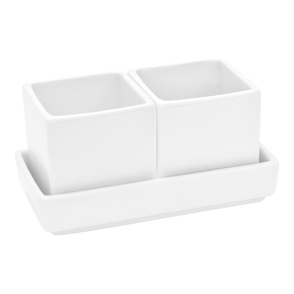 A set of two small, bright white rectangular porcelain ramekins on a matching tray.