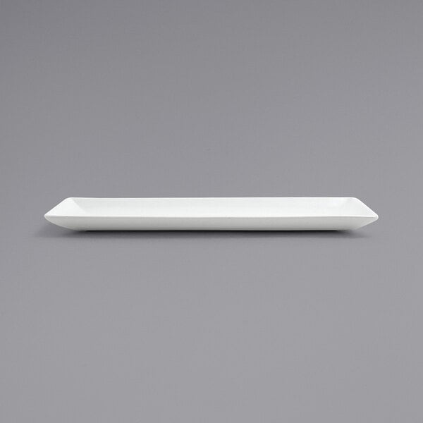 A Front of the House Bright White rectangular porcelain plate on a gray surface.
